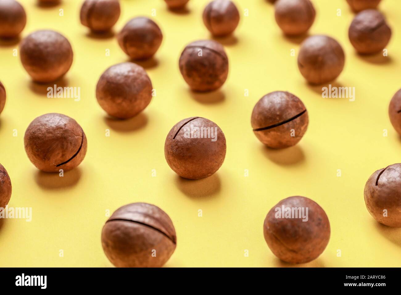Tasty macadamia nuts on color background Stock Photo
