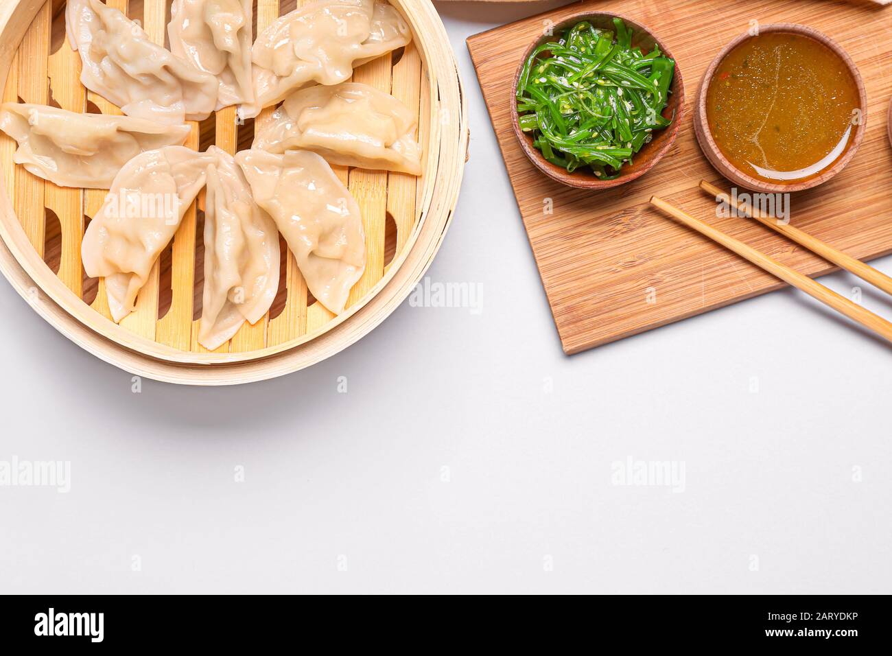 Bamboo steamer with tasty Japanese gyoza on white background Stock