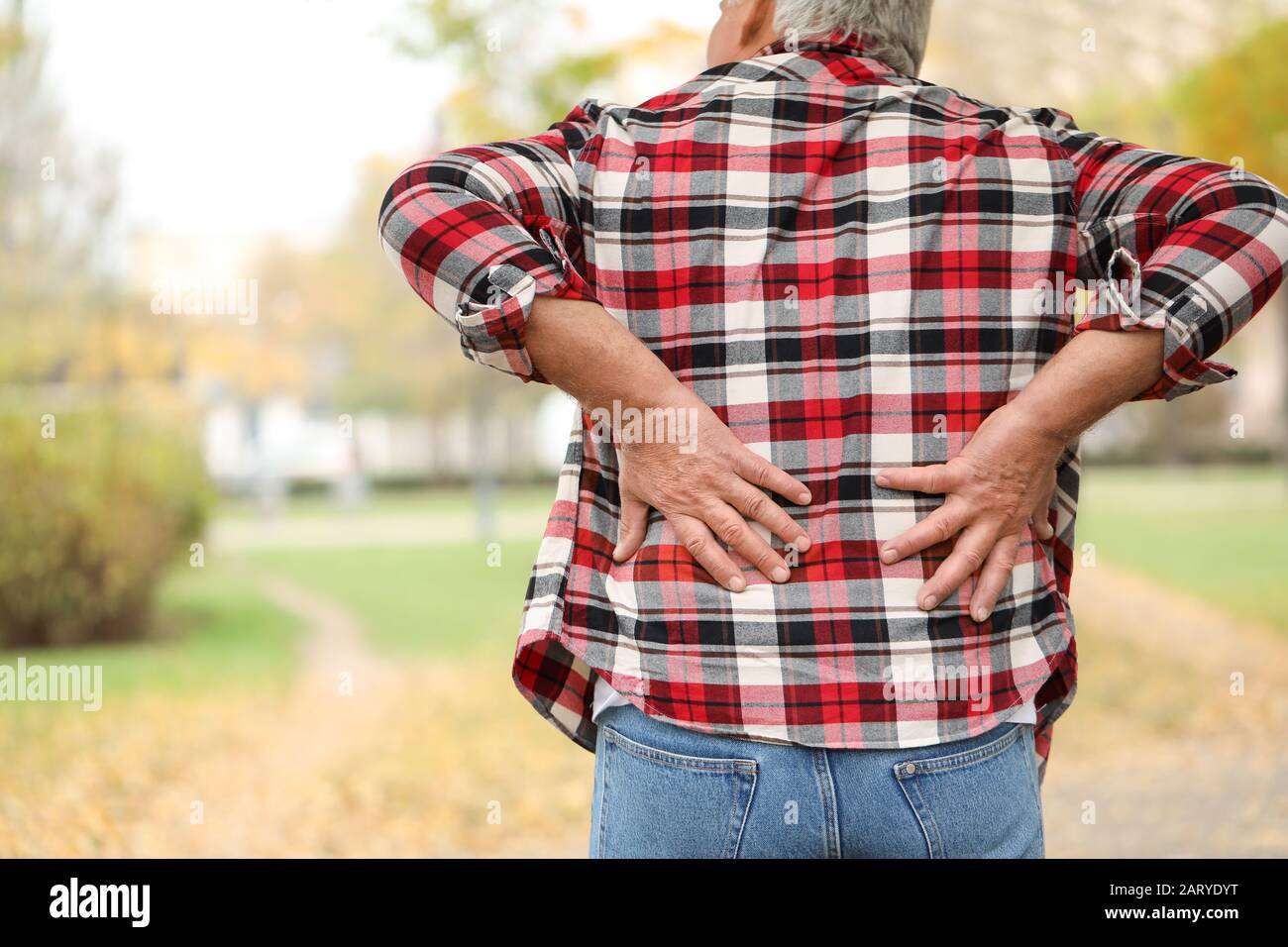 Senior man suffering from back pain outdoors Stock Photo - Alamy