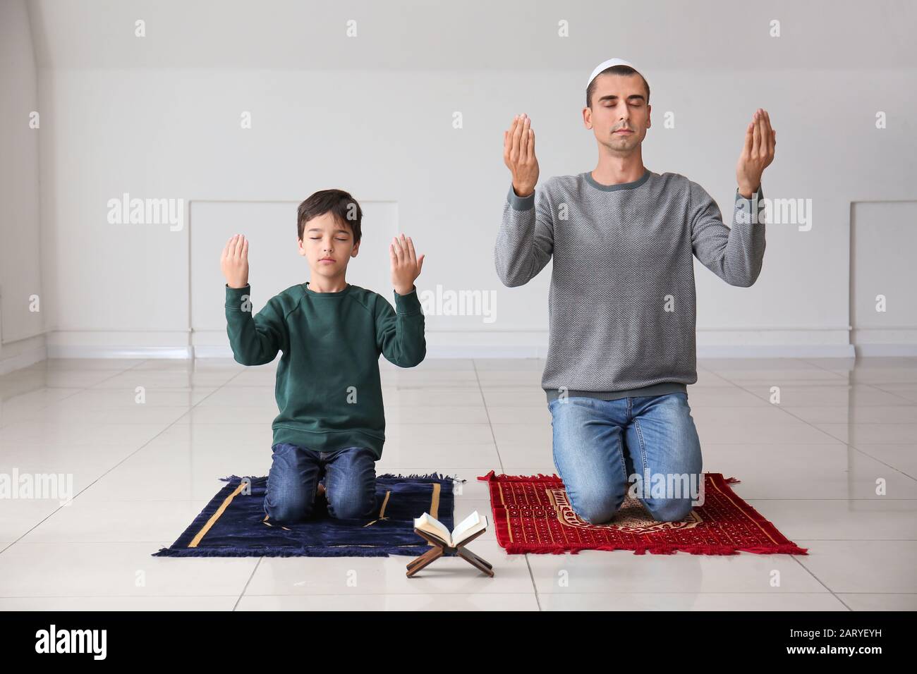 Muslim boy with father praying indoors Stock Photo - Alamy