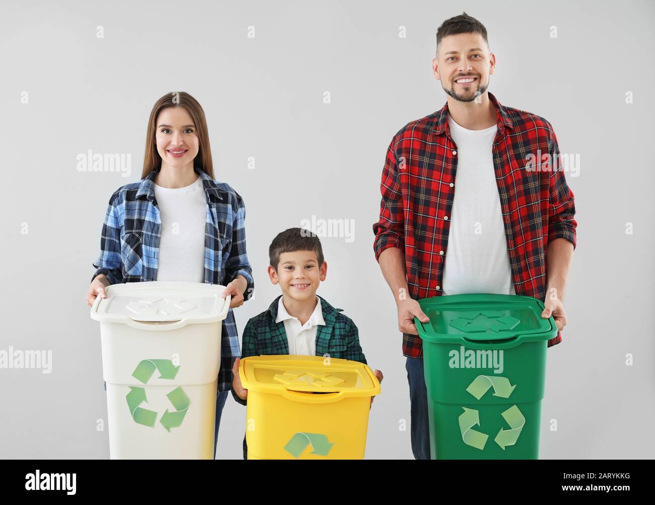 Family with containers for garbage on light background. Concept of ...