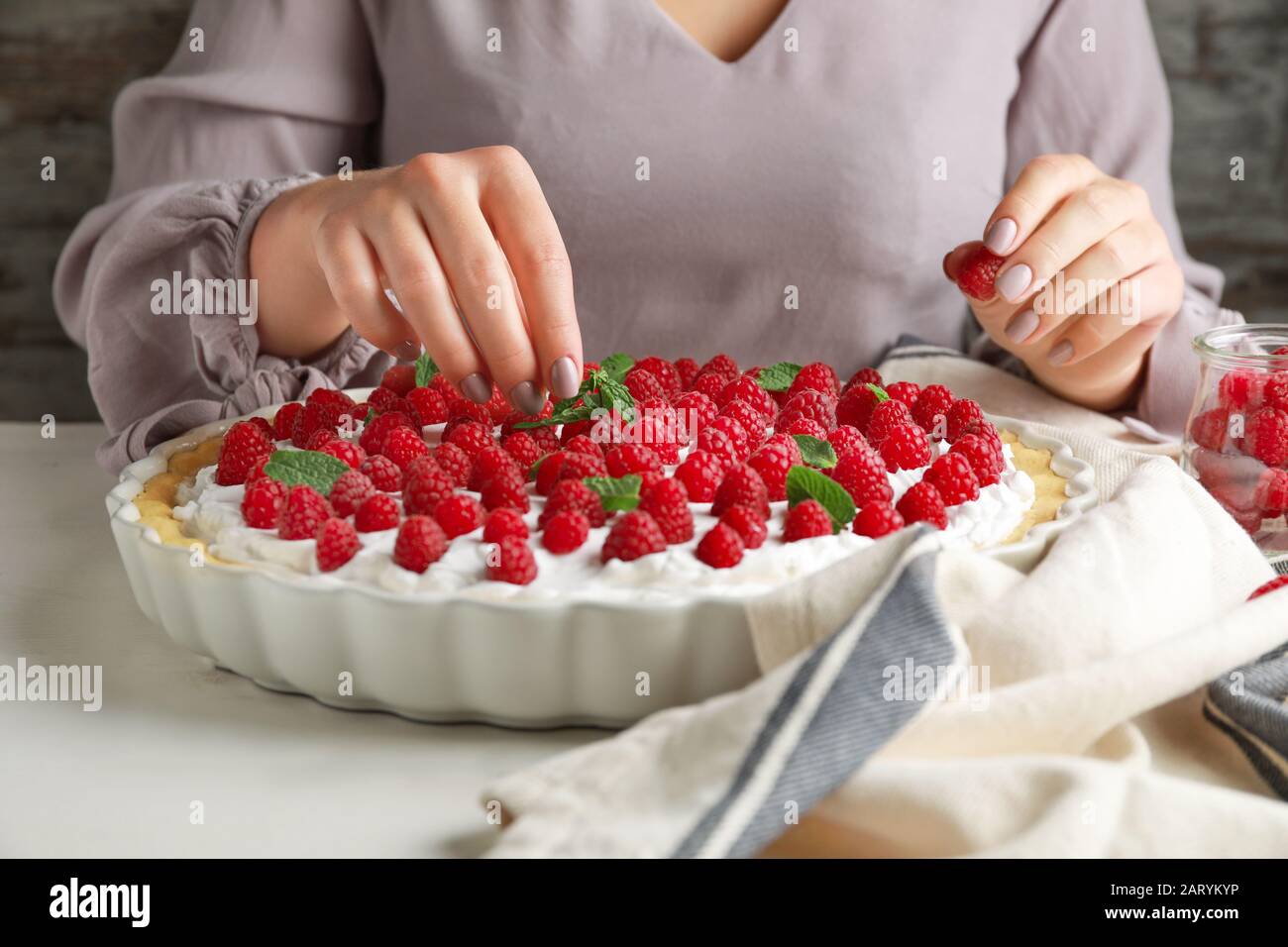 Woman decorating tasty raspberry hi-res stock photography and images ...