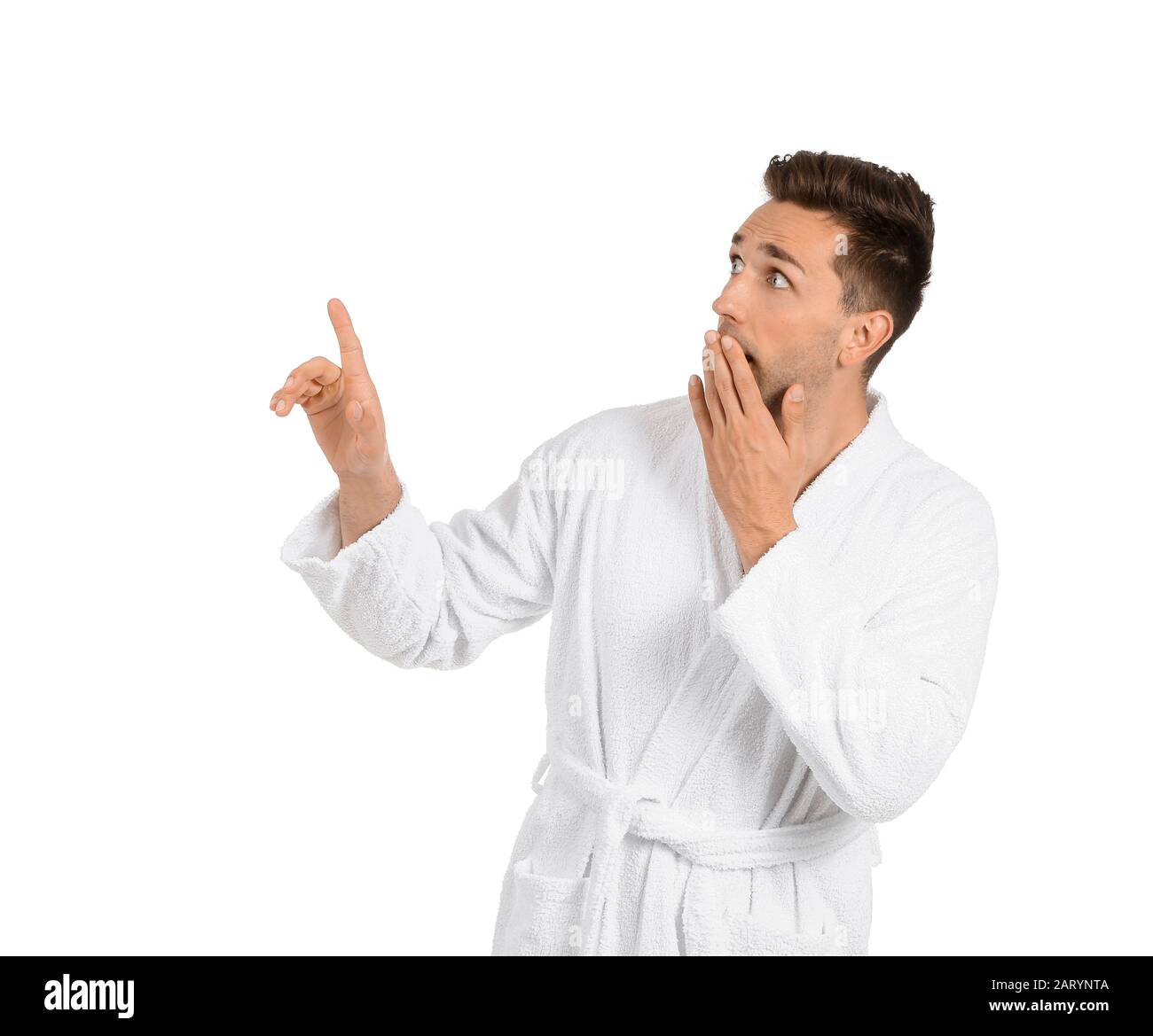 Surprised man in bathrobe pointing at something on white background Stock Photo