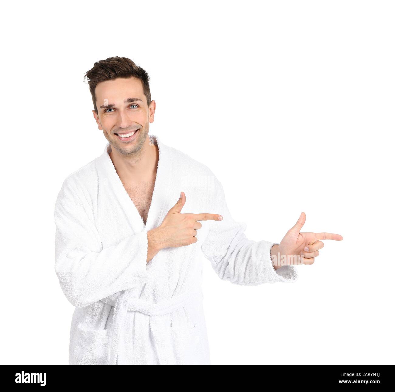 Handsome man in bathrobe pointing at something on white background Stock Photo