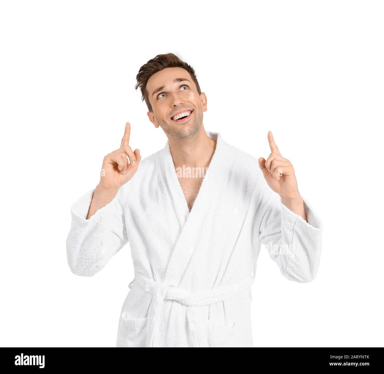 Handsome man in bathrobe pointing at something on white background Stock Photo