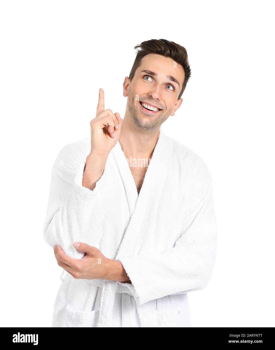 Handsome man in bathrobe pointing at something on white background Stock Photo
