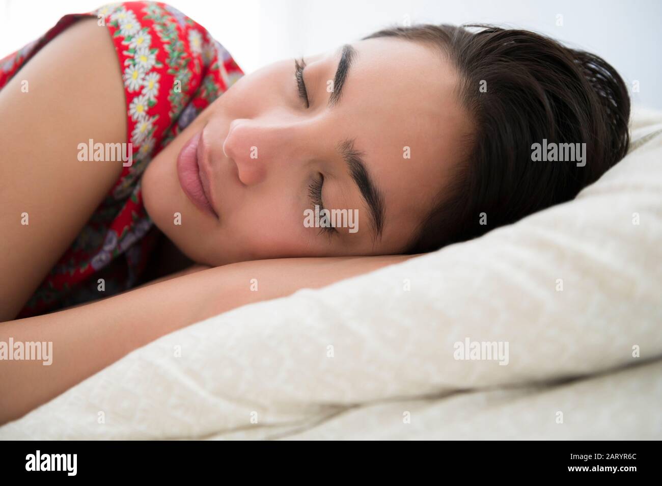 Sleeping woman lying down on bed Stock Photo