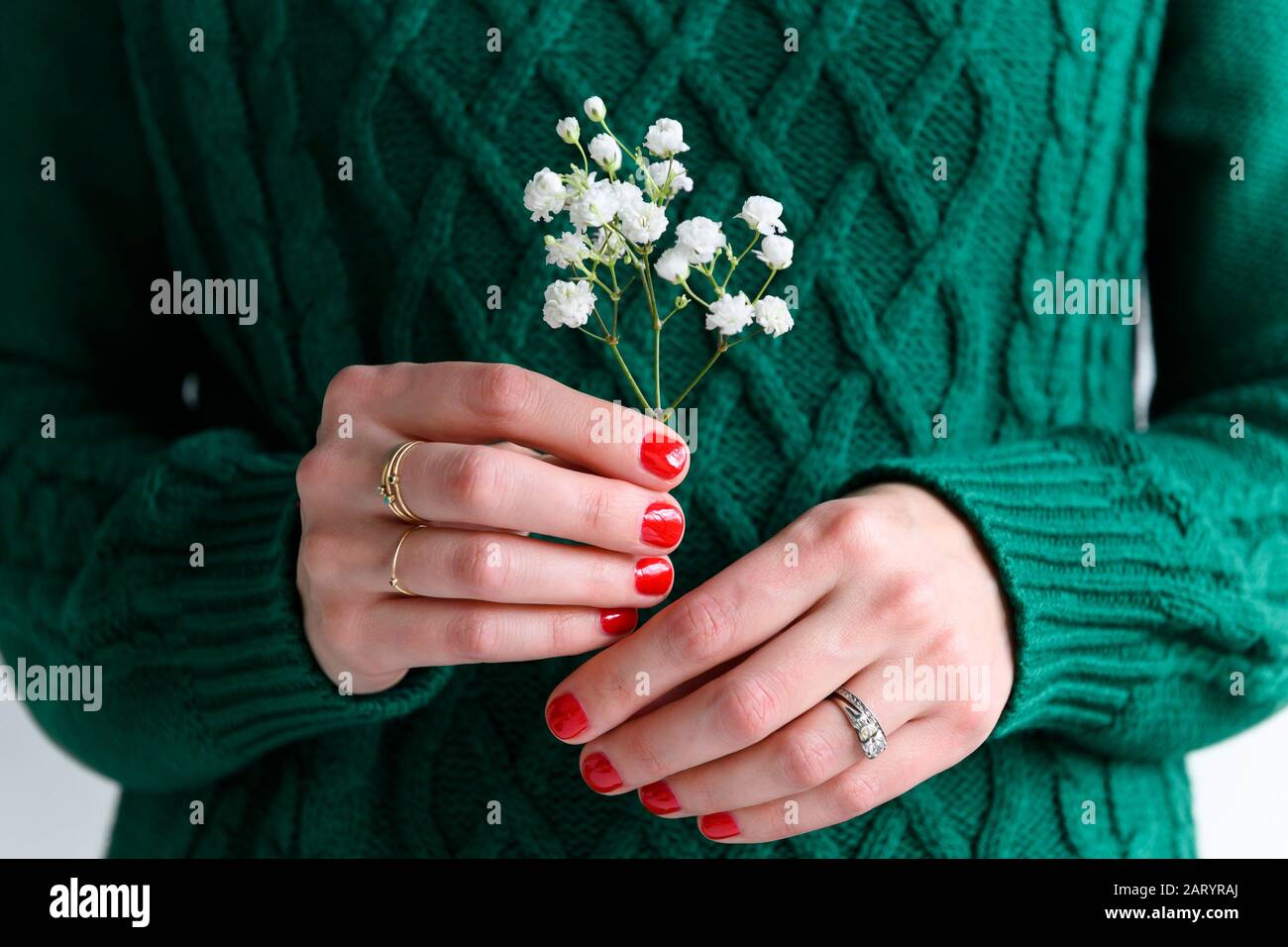Woman wearing green holding white flowers Stock Photo