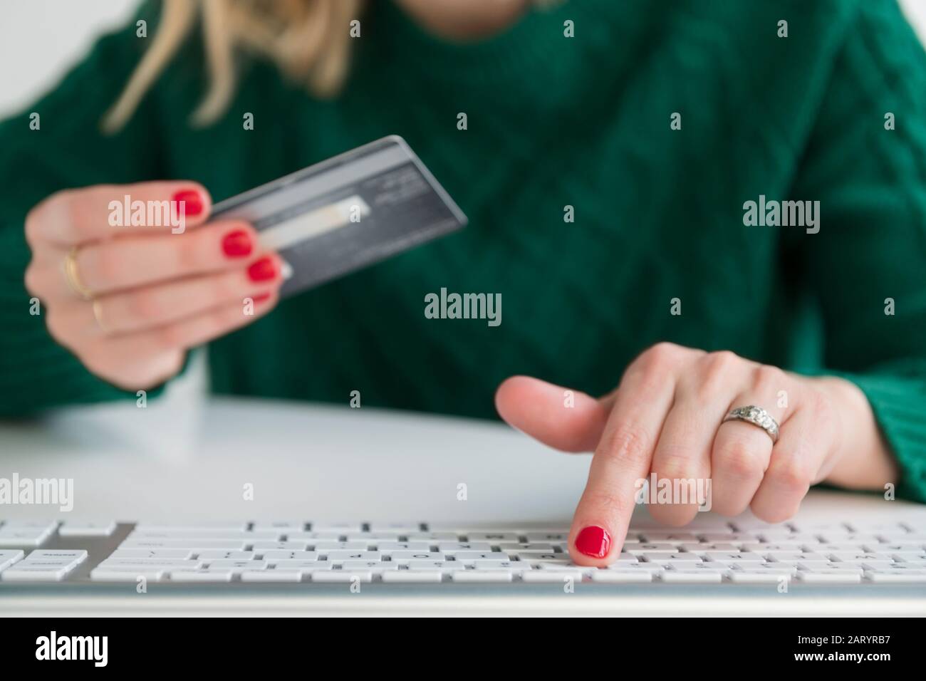 Woman holding credit card and typing on keyboard Stock Photo