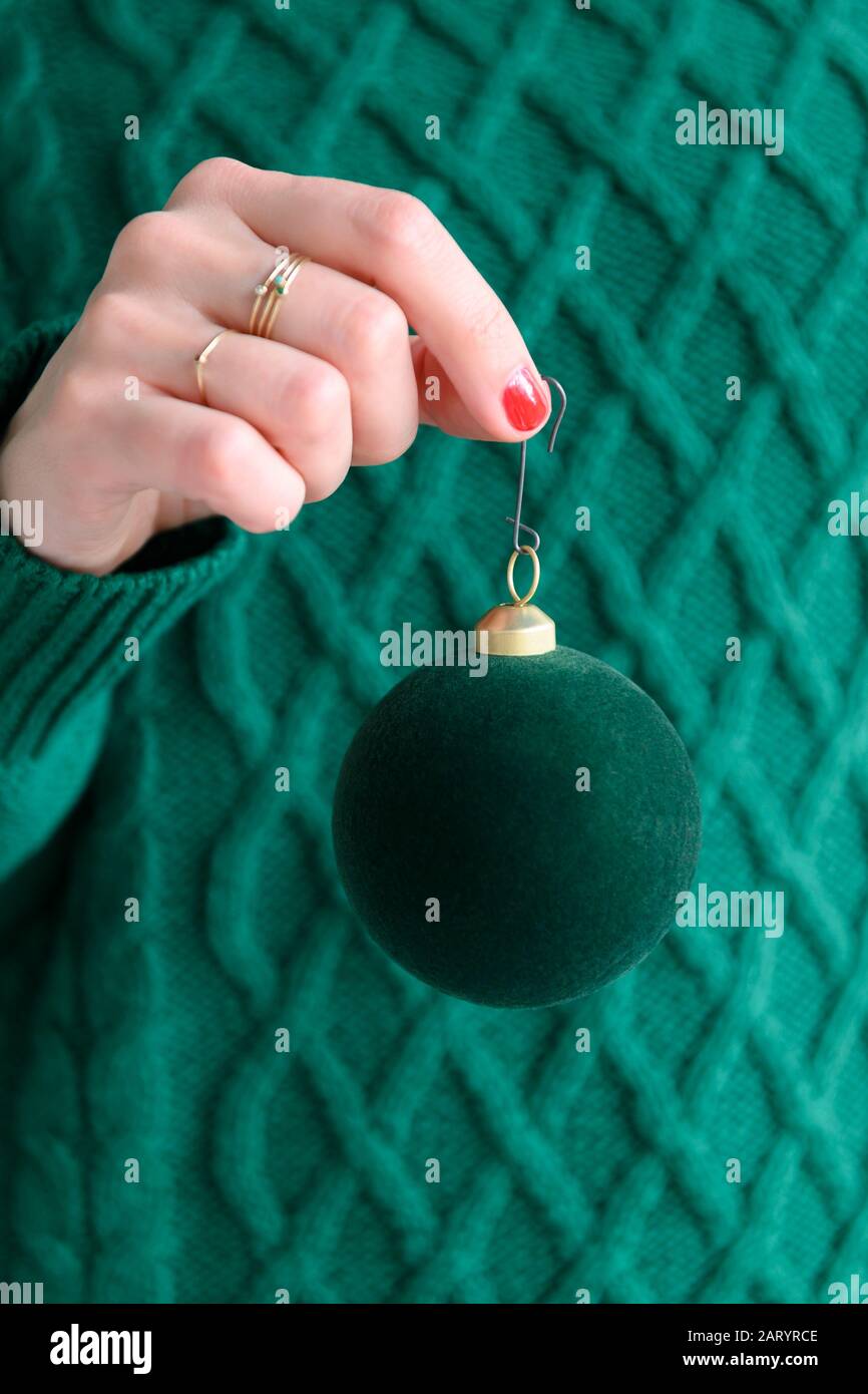 Woman wearing green holding green bauble Stock Photo