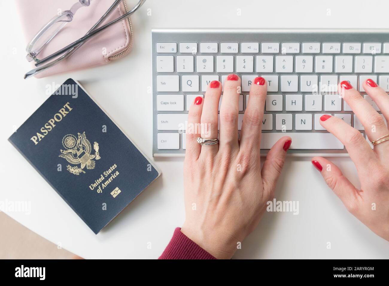 Woman typing on keyboard by passport Stock Photo
