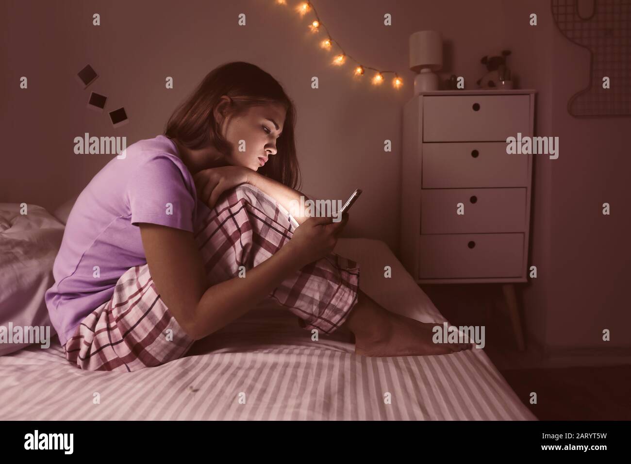 Teenage girl with mobile phone in bedroom at night Stock Photo - Alamy