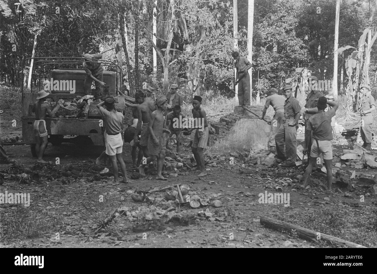 Unknown [a.o. medical care]  Military debris is taken out of a truck for the hardening of a road Date: 1948 Location: Indonesia, Dutch- India Stock Photo