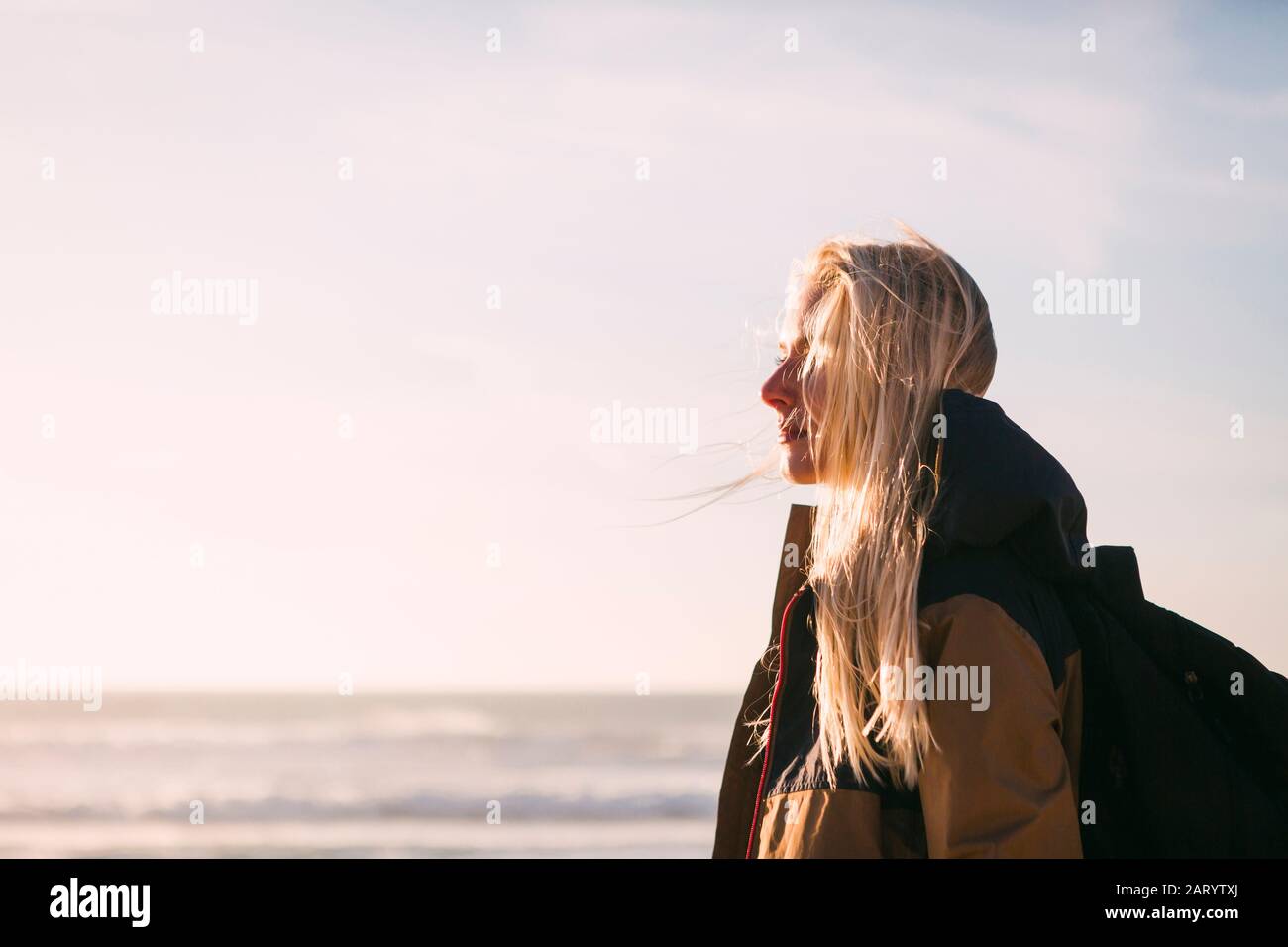 Woman wearing backpack by sea Stock Photo