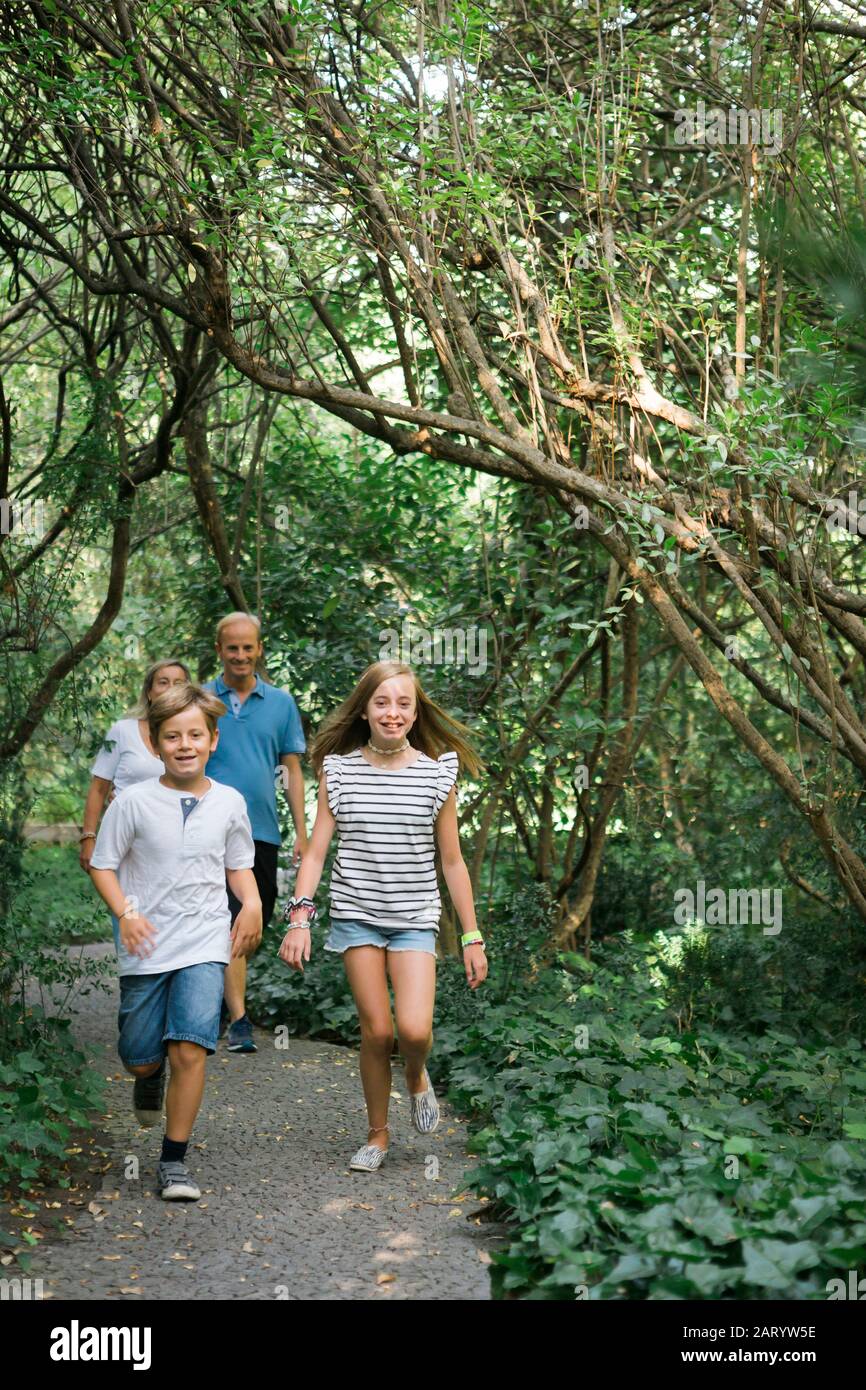 Family walking on path in forest Stock Photo