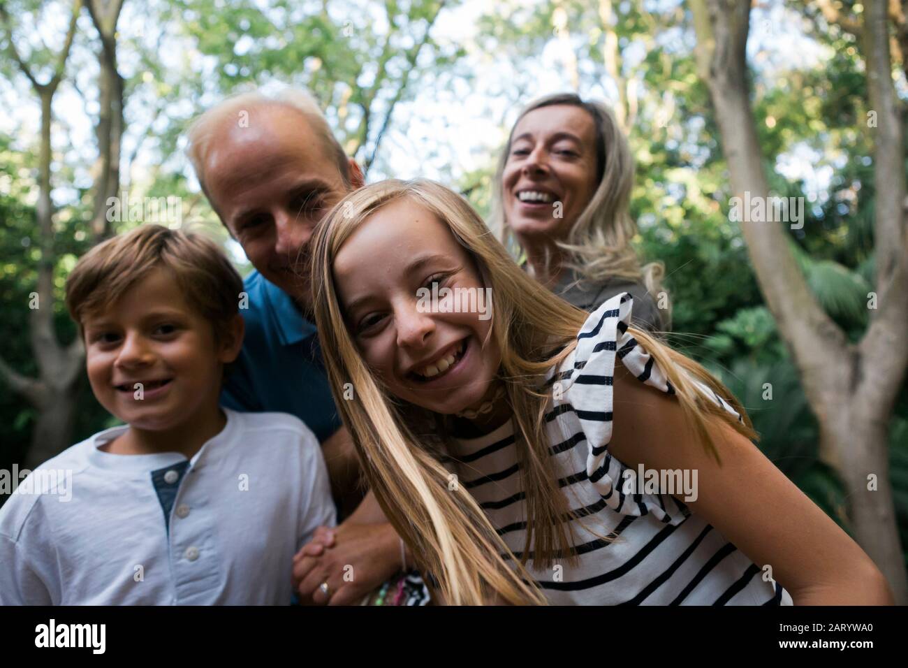 Family smiling by trees Stock Photo