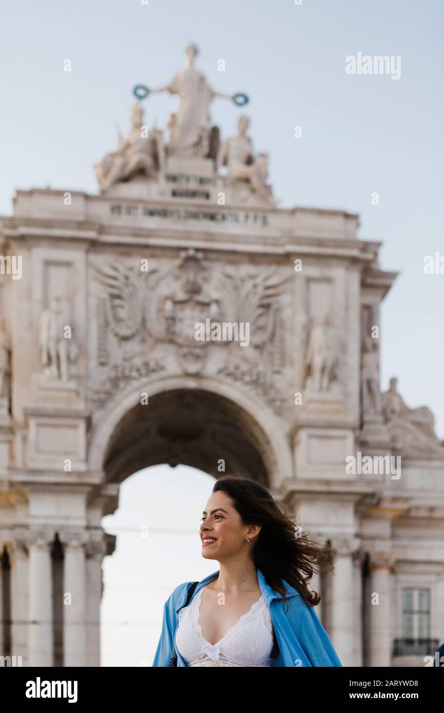 Smiling woman by Rua Augusta Arch in Lisbon, Portugal Stock Photo