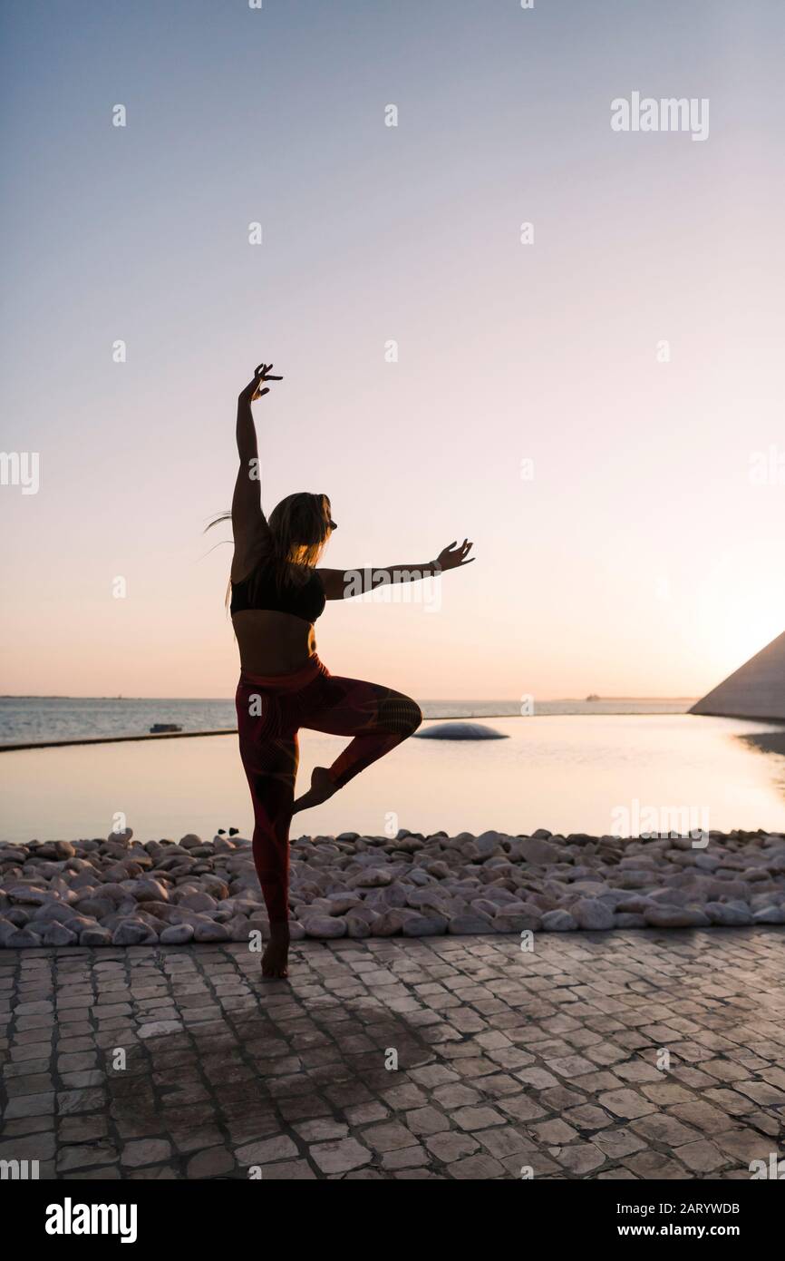 Silhouette of woman dancing at sunset Stock Photo