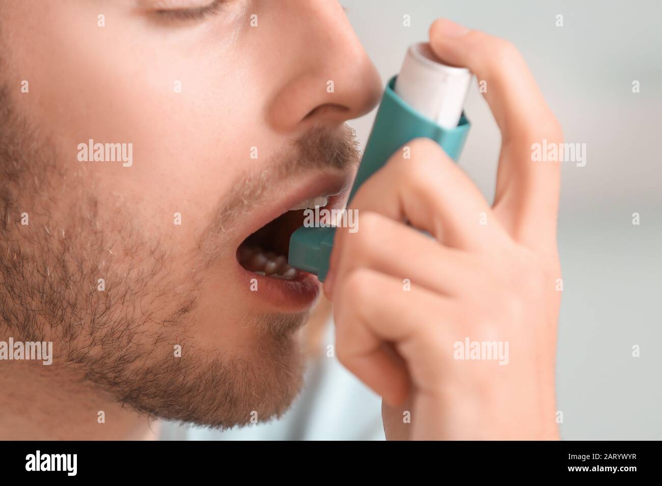 Sick man with inhaler at home, closeup Stock Photo - Alamy