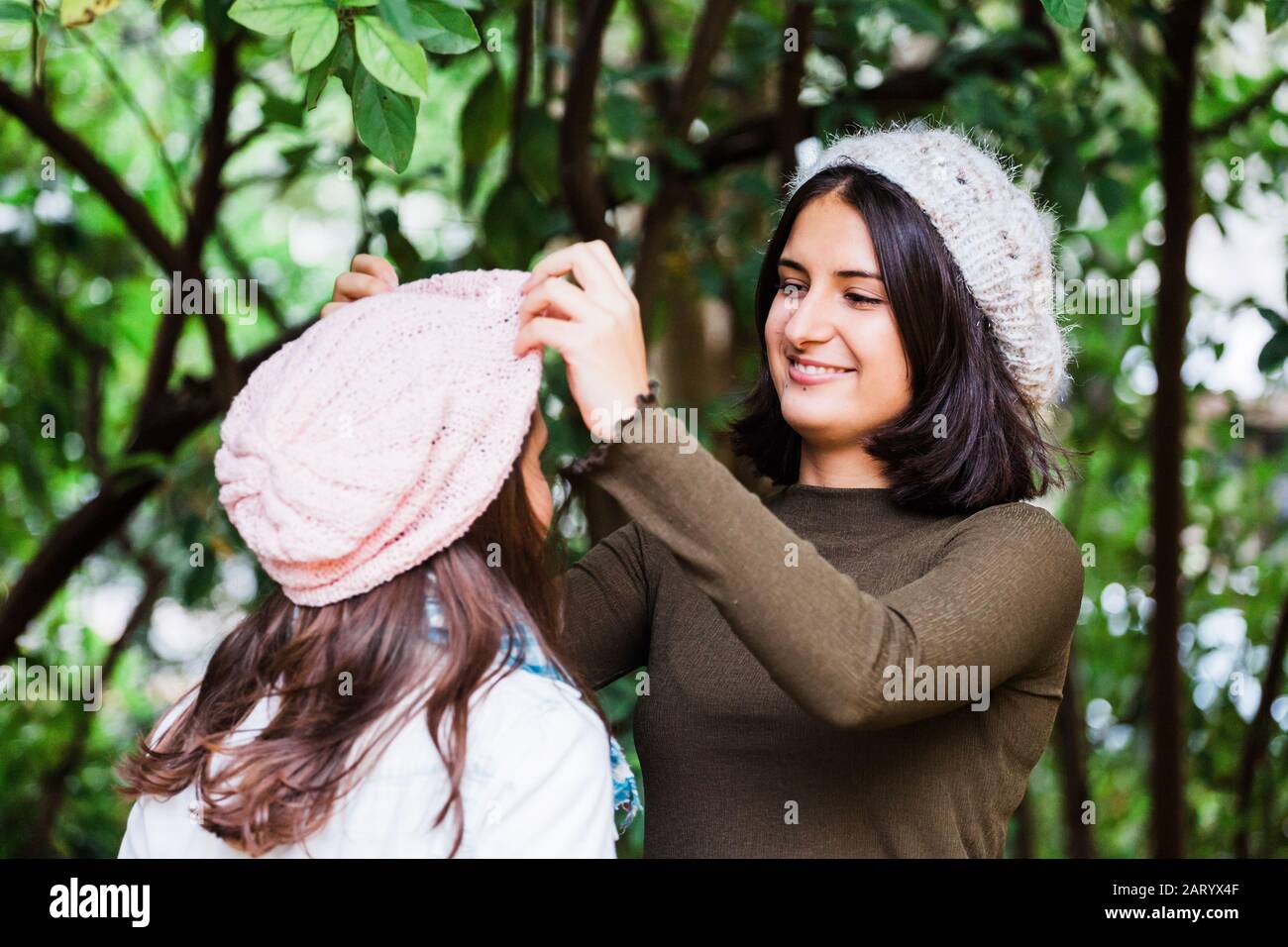 Girl adjusting sister's hat Stock Photo