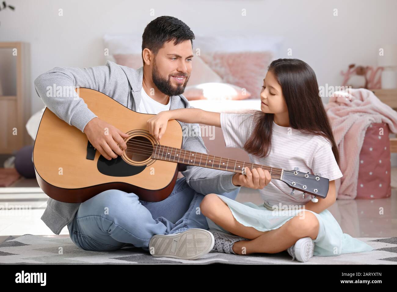 Little daughter and her father playing guitar at home Stock Photo - Alamy