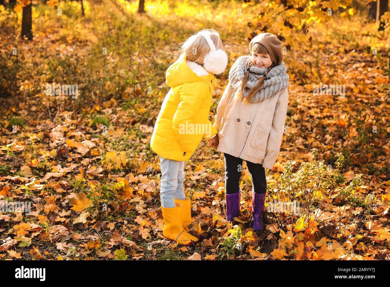 Cute little girls in autumn park Stock Photo - Alamy