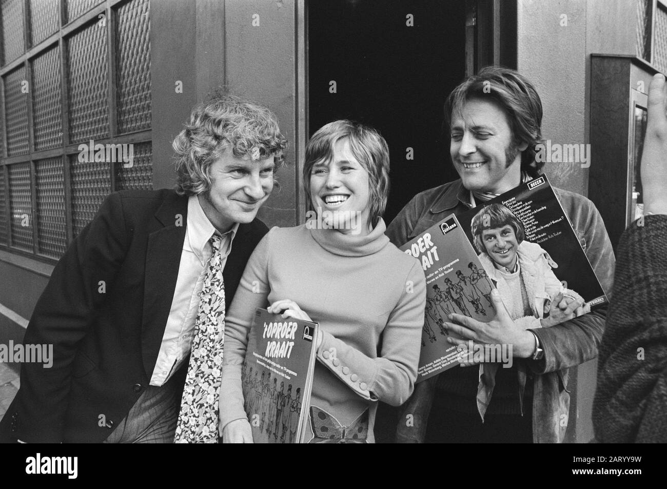 New album by Gerard Cox ('Wie points Gerard Cox de road') and Jaap van de Merwe ('Riot crow') in Amsterdam  V.l.n.r. Gerard Cox, Jenny Arean and Rob Touber, on the right the arm of Jaap van de Merwe Date: 30 March 1971 Location: Amsterdam, Noord-Holland Keywords: gramophone records, musicians, singers Personal name: Arean, Jenny, Cox, Gerard, Touber, Rob Stock Photo