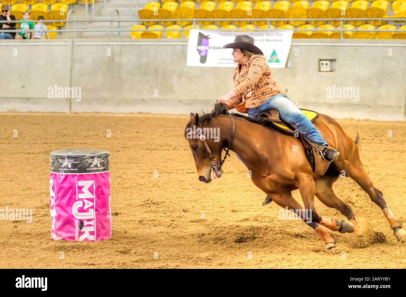 Lady competing in a barrel race at an indoor arena at Tamworth Australia. Stock Photo
