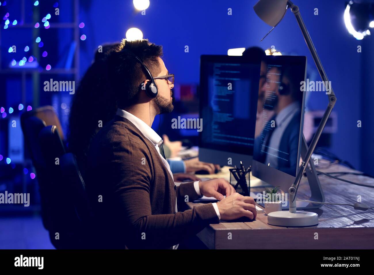 Technical support agents working in office at night Stock Photo - Alamy