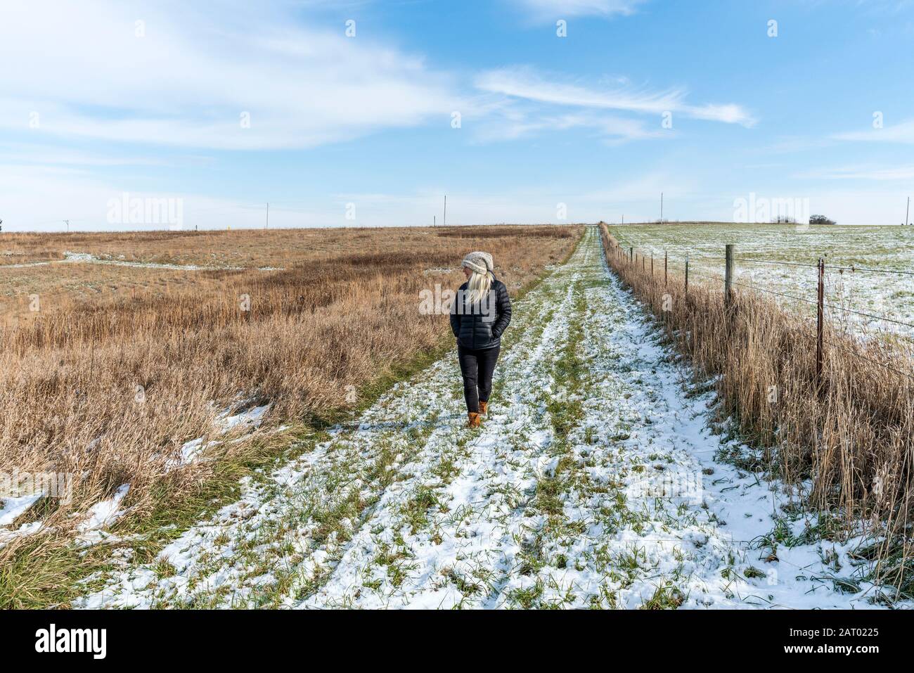 Woman walking in snowy field Stock Photo - Alamy