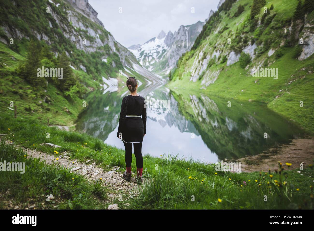 Woman by mountains and lake in Appenzell, Switzerland Stock Photo