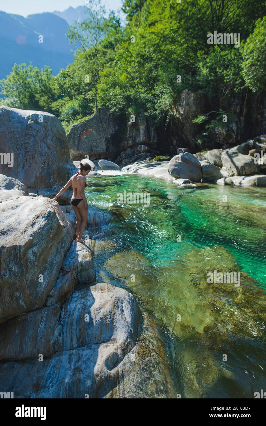 Woman wearing bikini on rock by river Stock Photo Alamy