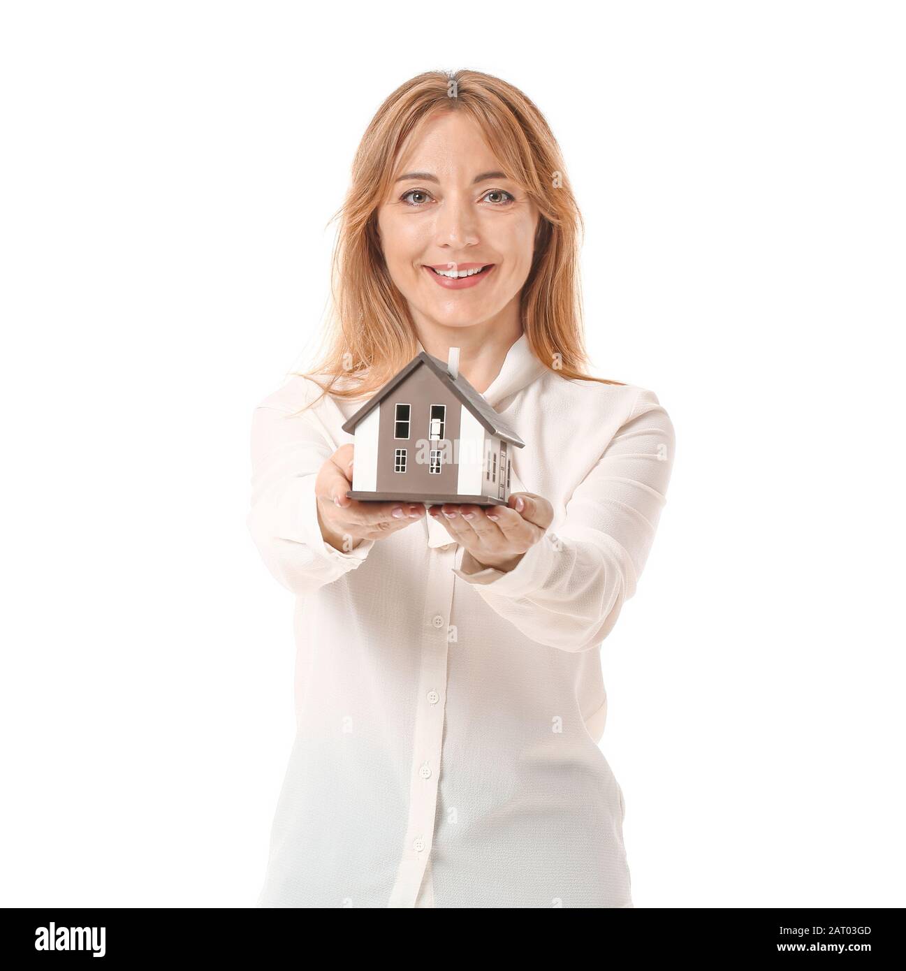 Female real estate agent with model of house on white background Stock