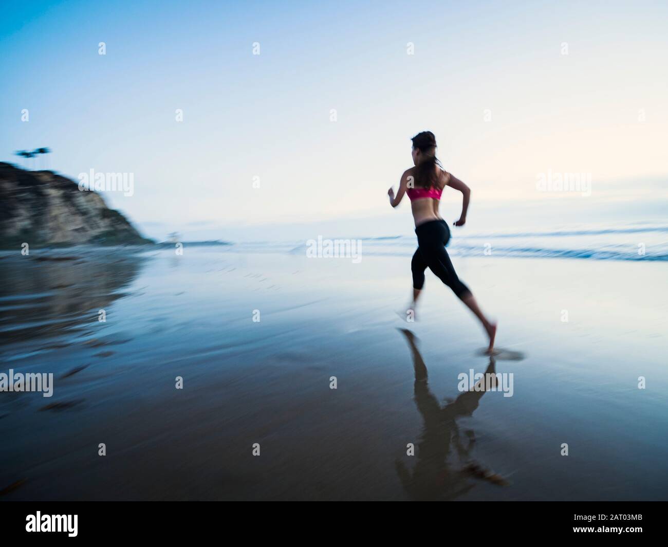 Young woman running on beach Stock Photo