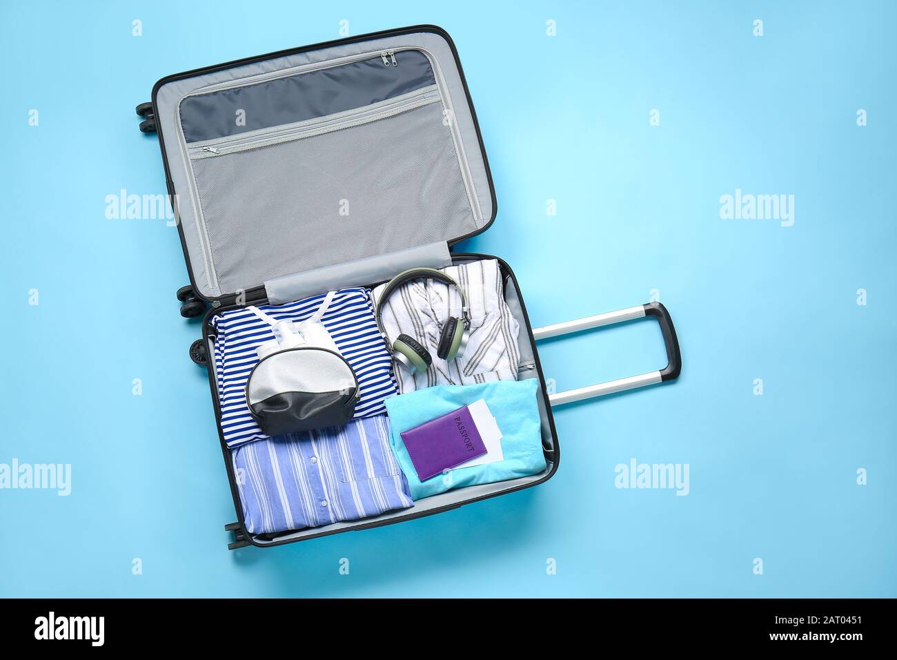 Suitcase with packed clothes, passport and accessories on color background Stock Photo Alamy