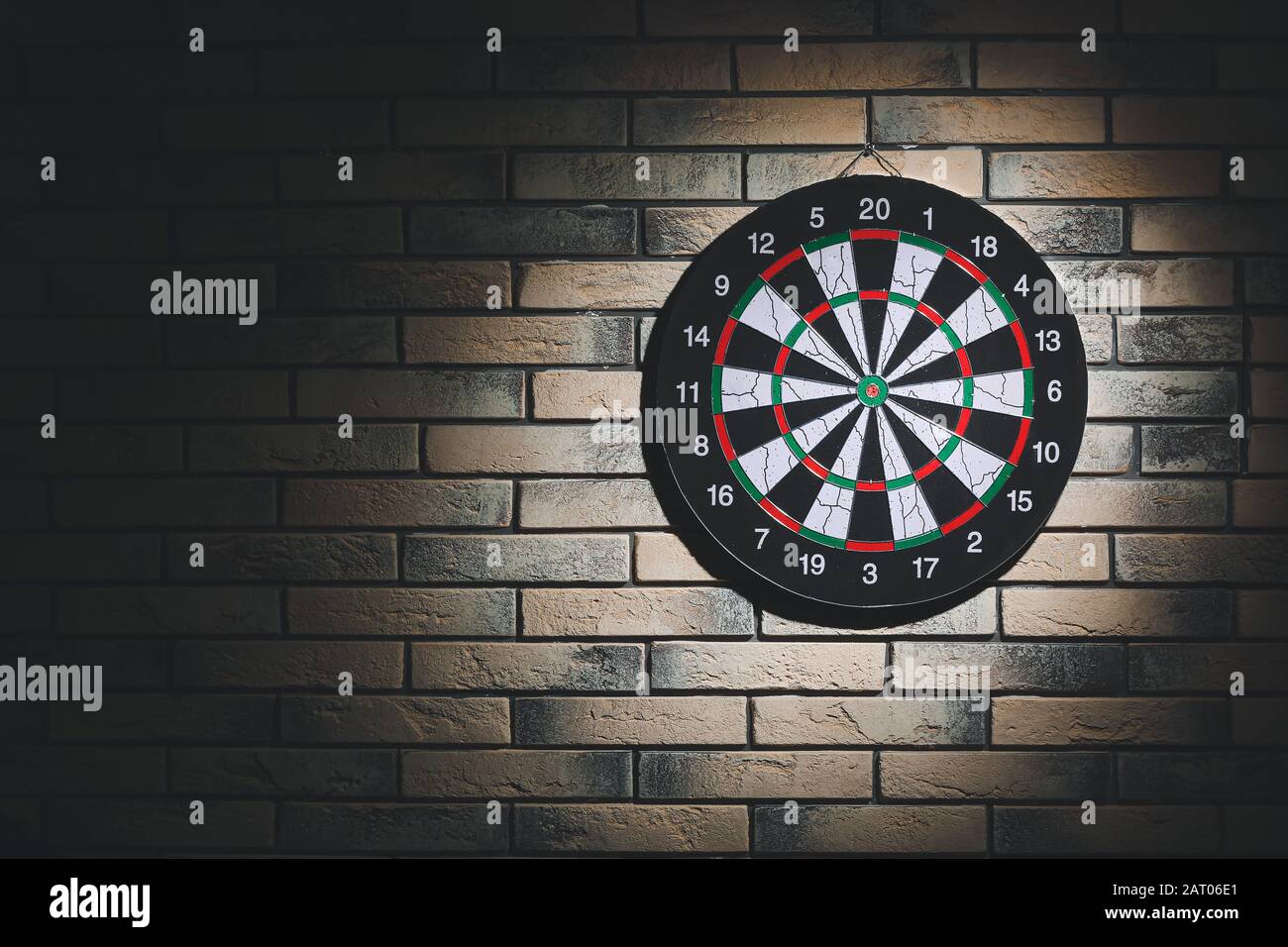 Dartboard hanging on brick wall Stock Photo Alamy