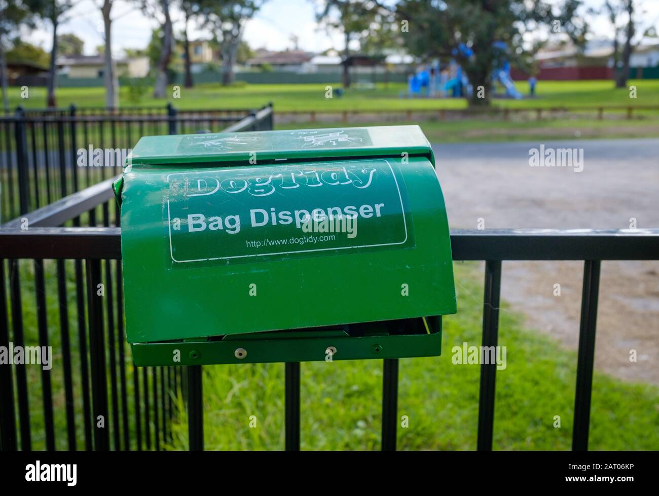 Dogtidy Bag Dispenser, empty and battered, on dog park railing in NSW, Australia Stock Photo