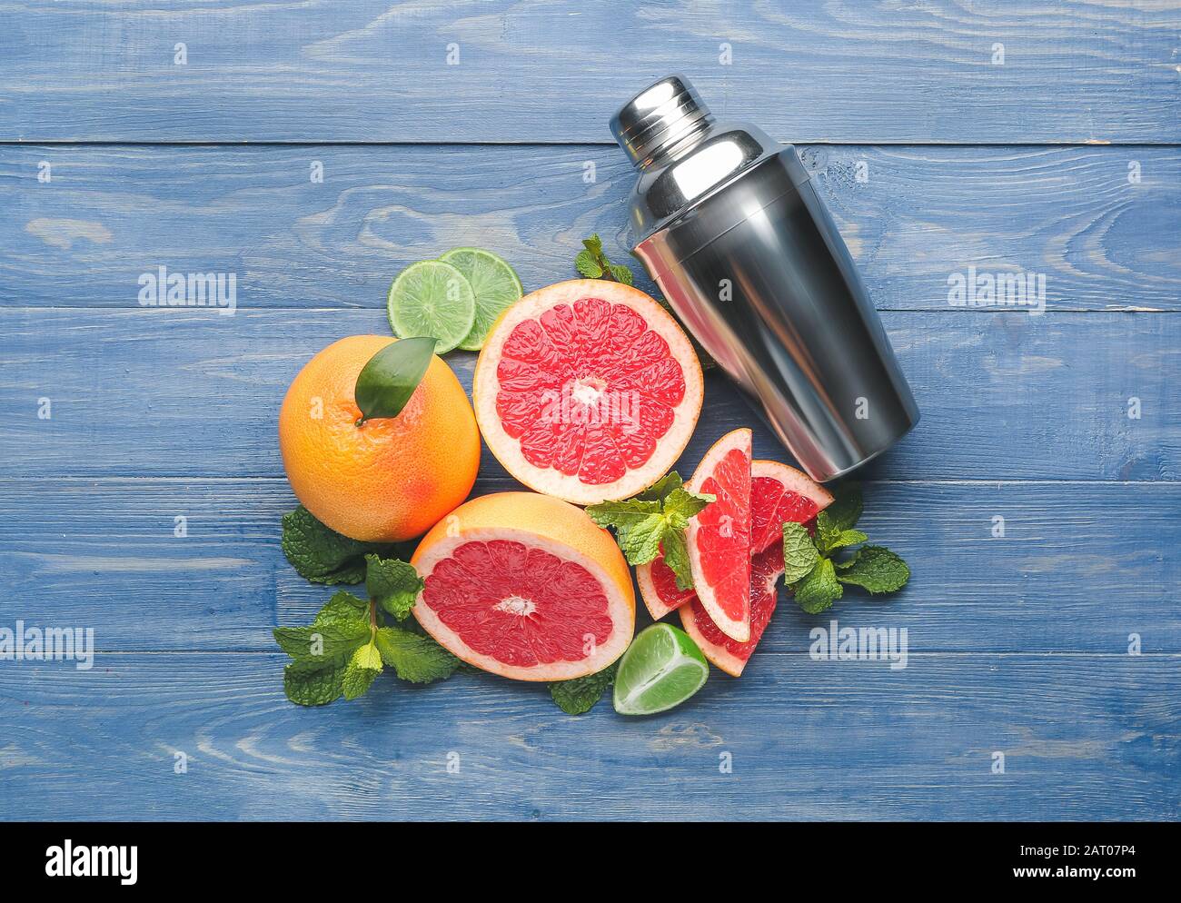 Fresh grapefruits, lime and shaker on table Stock Photo