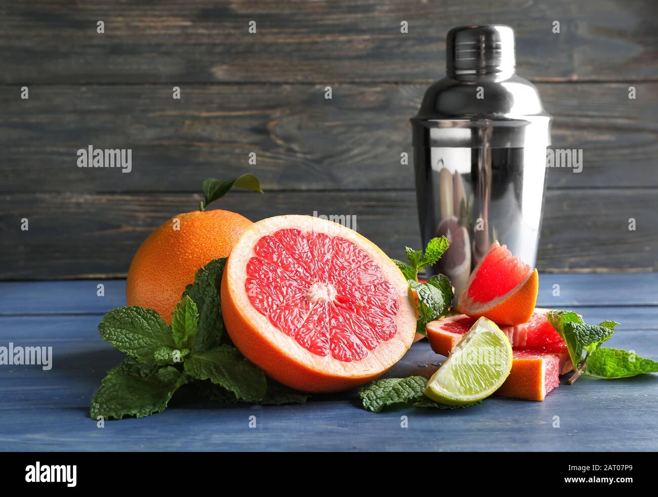 Fresh grapefruits, lime and shaker on table Stock Photo