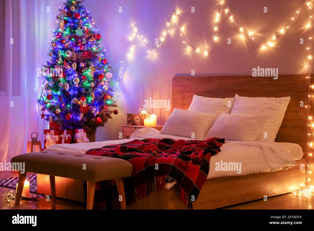 Interior of bedroom with beautiful decorated Christmas tree at ...