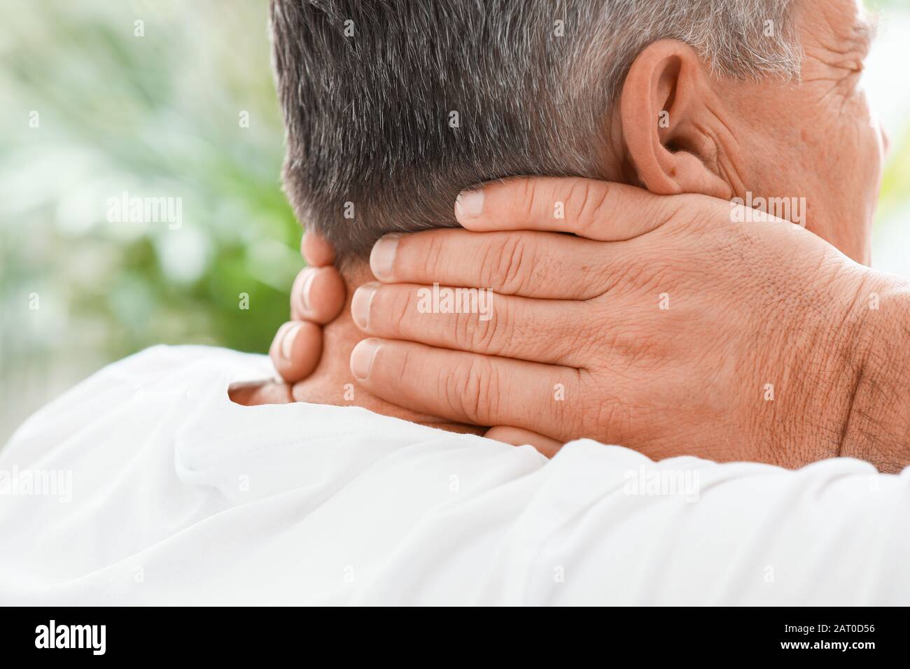 Mature man suffering from neck pain at home, closeup Stock Photo - Alamy