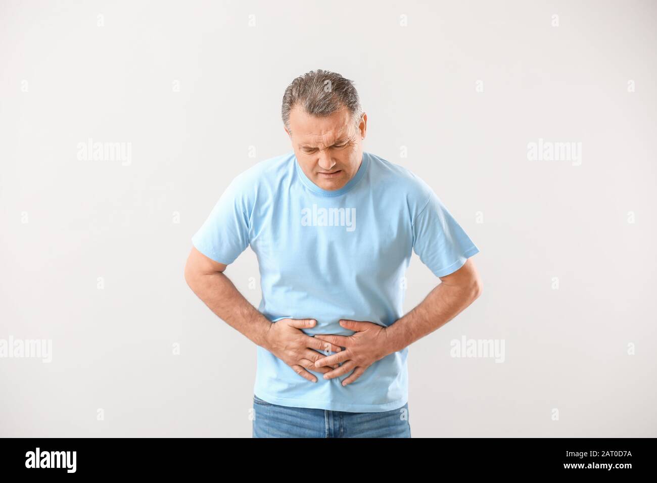 Mature man suffering from abdominal pain on white background Stock ...