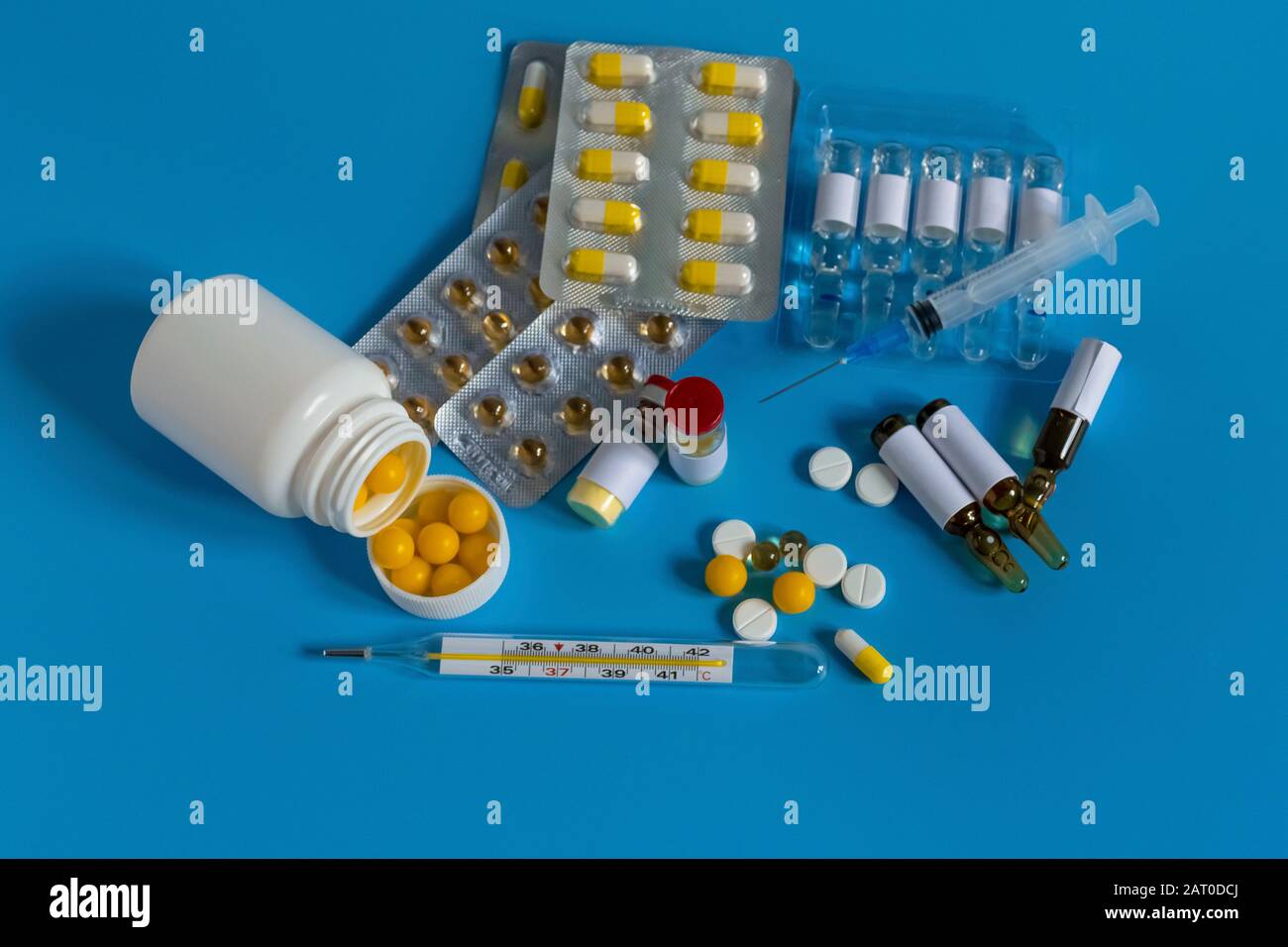 A bottle of medicine next to a syringe. Medicines for the virus and flu. Medical pills and antibiotics. Coronavirus, personal protective equipment, di Stock Photo