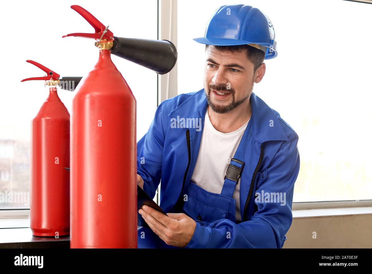 Fire safety specialist inspecting extinguisher Stock Photo Alamy