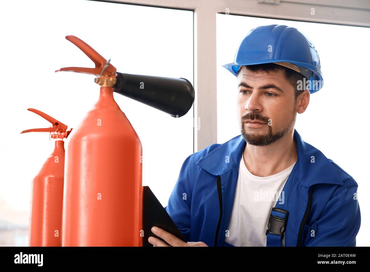 Fire safety specialist inspecting extinguisher Stock Photo