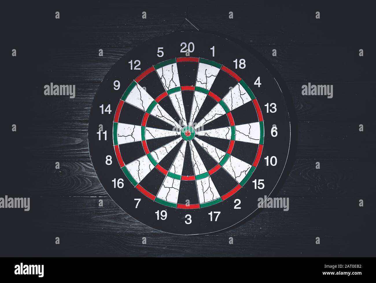 Dartboard hanging on dark wall Stock Photo Alamy