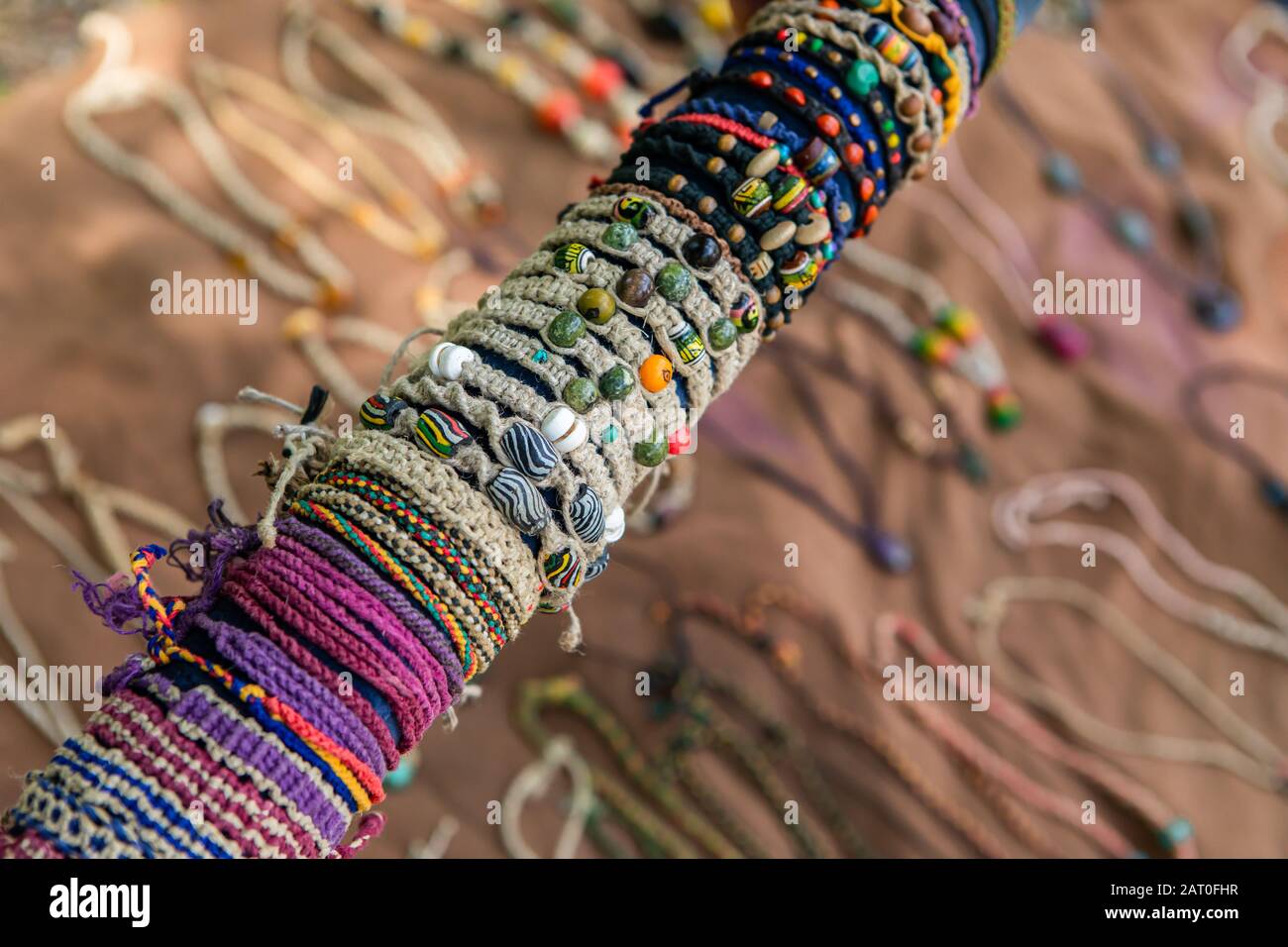 Colored hand made bracelets in the hippie craft stand in the farmer's Market.  natural and colored strings, beads, small stones. Blurry background Stock  Photo - Alamy