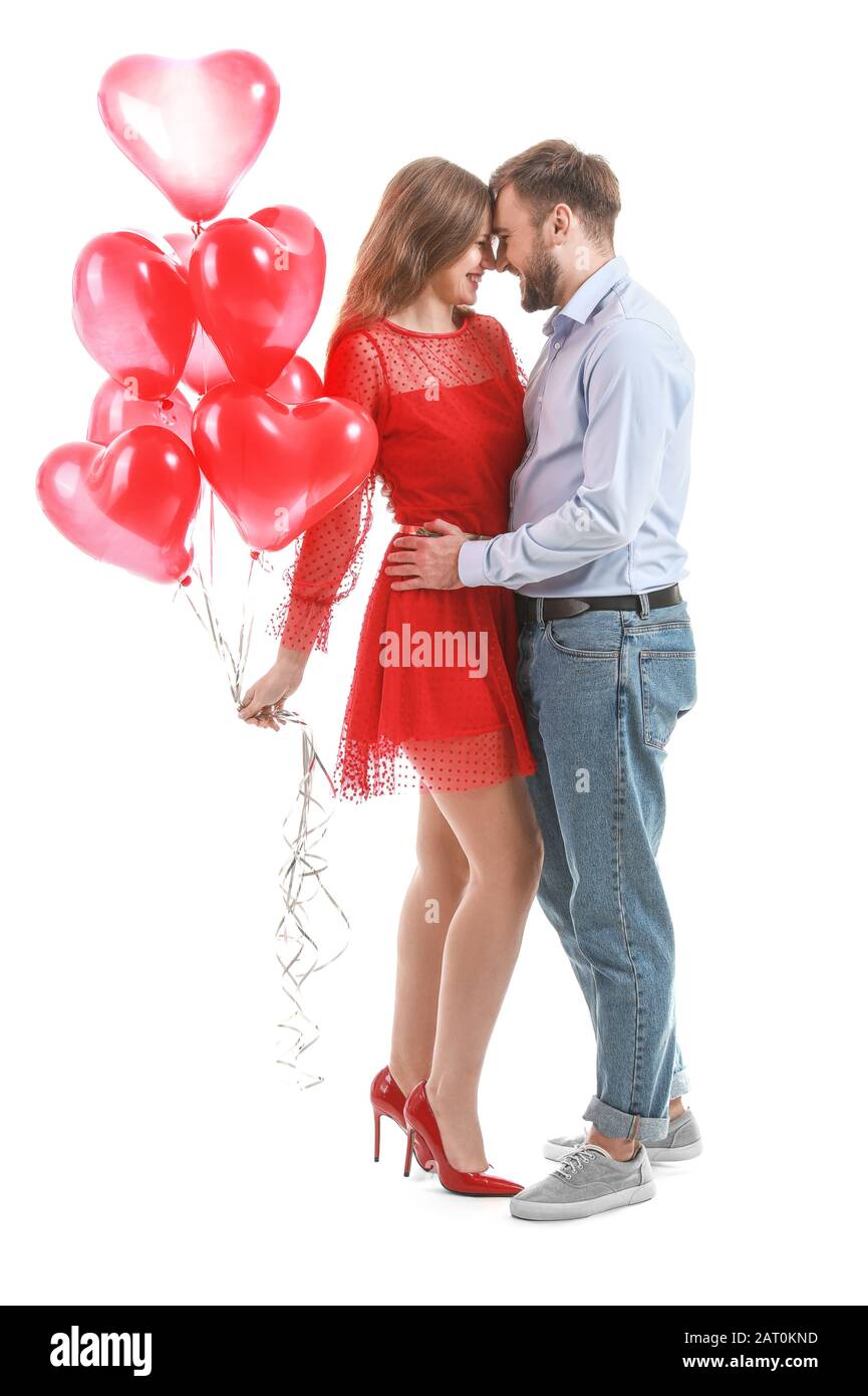 Happy young couple with heart-shaped balloons on white background ...
