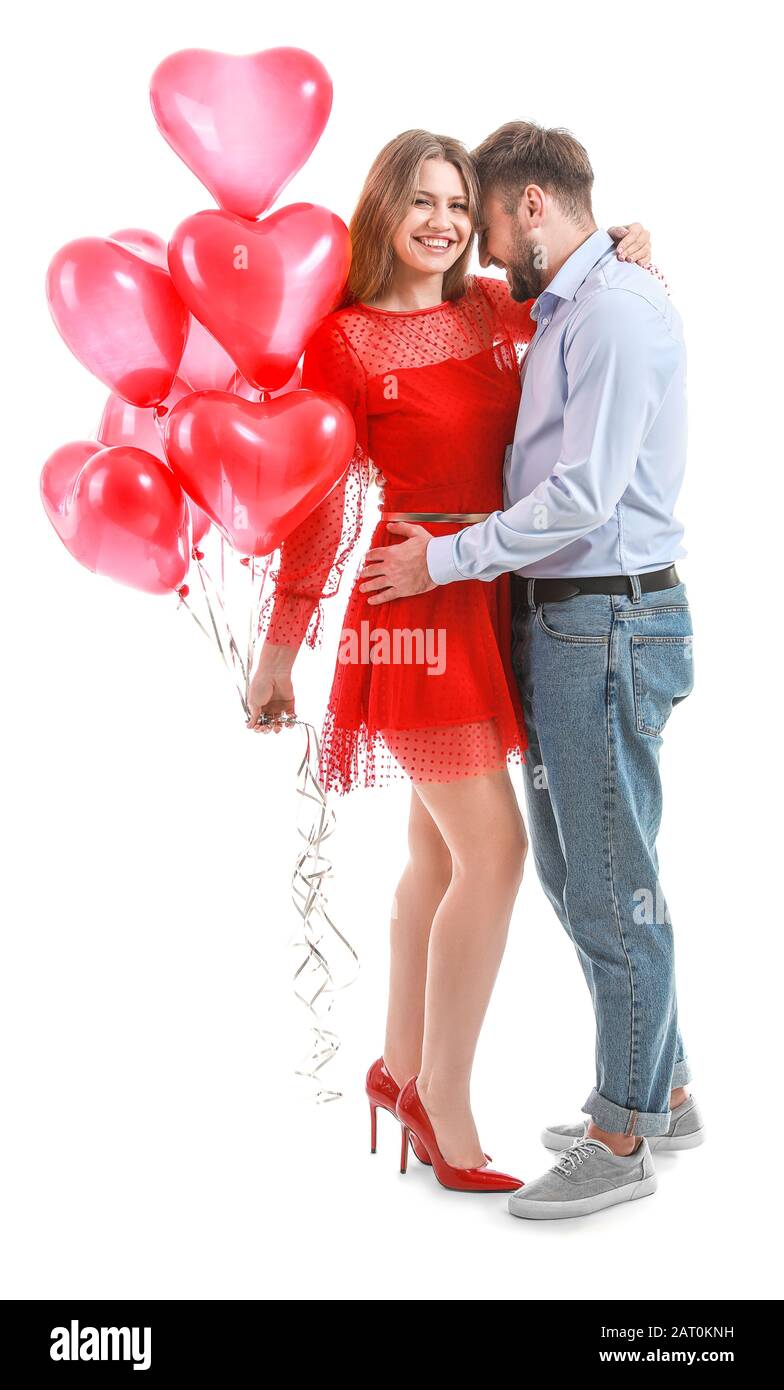 Happy young couple with heart-shaped balloons on white background ...