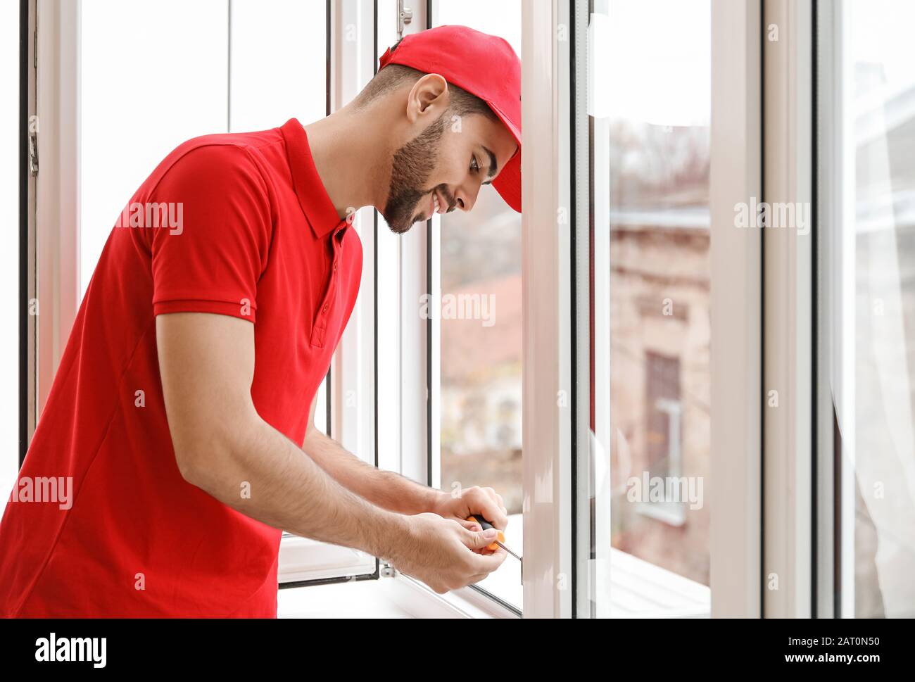 Young worker installing window in flat Stock Photo